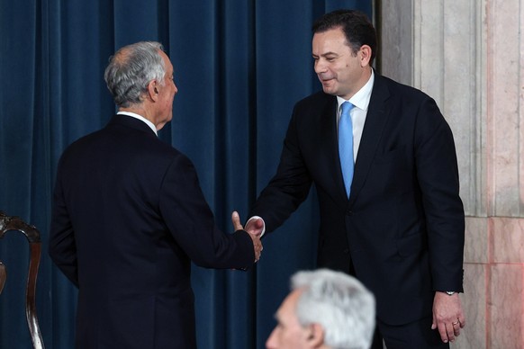 epa11255817 New Portuguese Prime Minister Luis Montenegro (R) shakes hands with Portuguese President Marcelo Rebelo de Sousa (L) during the swearing in ceremony of the XXIV Constitutional Government a ...