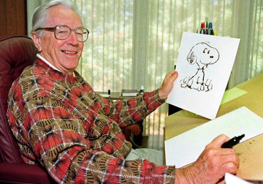FILE --- Cartoonist Charles Schulz displays a sketch of his beloved character "Snoopy" in his office in Santa Rosa, Calif. in 1997. Schulz was reported dead by his son at his home in Santa R ...