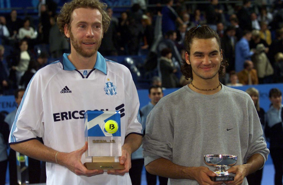 Marc Rosset ( L) and Roger Federer of Switzerland hold their trophies after the final of the Open 13 tennis tournament in Marseille February 13. Rosset won the match 2-6,6-3,7-6 - RTXJIOO