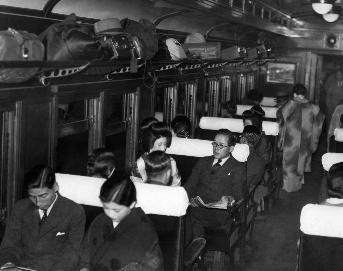 The Honeymoon Train leaves Tokyo Station at 9:15 p.m., Dec. 15, 1936, after there has been ample time for the elaborate wedding banquets and receptions. Most of the train's passengers are young c ...