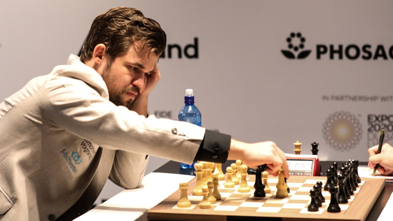 epa09623815 Defending Champion Magnus Carlsen of Norway competes against Ian Nepomniachtchi (unseen) of Russia during the 8th round of FIDE World Chess Championship during the EXPO 2020 Dubai in Dubai ...