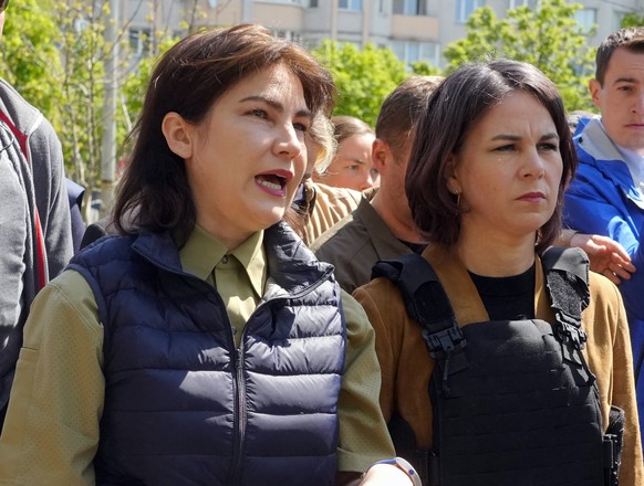 FILE - German Foreign Minister Annalena Baerbock, right, and Ukrainian Prosecutor General Iryna Venediktova talk as they stand near a mass grave in Bucha, on the outskirts of Kyiv, Ukraine, May 10, 20 ...