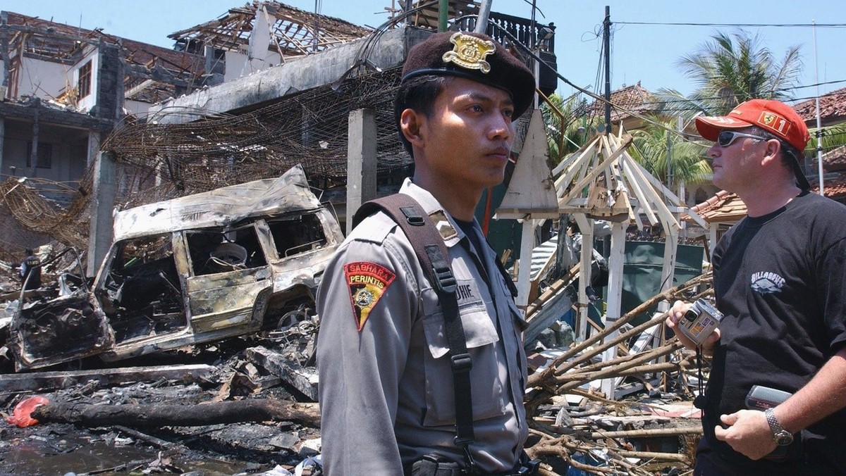 CYK34 - 20021013 - DENPASAR, BALI, INDONESIA : A foreign tourist (R) looks at the destroyed building of what remains of the Padi club the day after a bomb blast in Denpasar, on the Indonesian island o ...