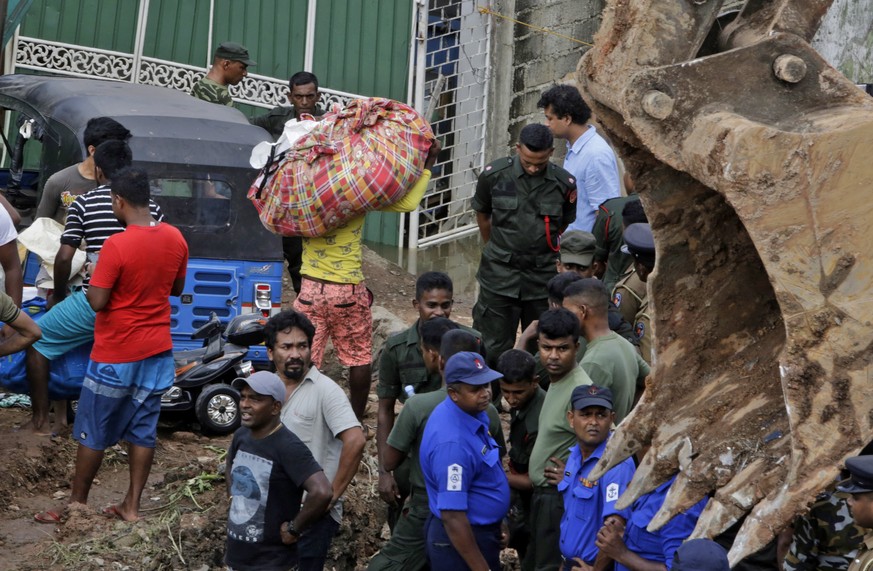 epa05908667 Sri Lankan rescue workers at the site of a collapsed garbage mountain in Colombo, Sri Lanka 15 April 2017. A fire broke out at a garbage dump that had grown into a huge man-made mountain m ...