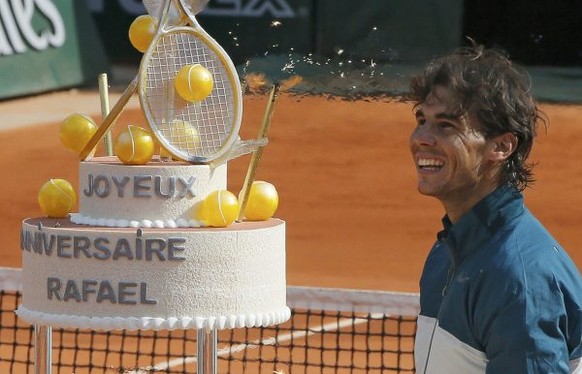 Rafael Nadal of Spain looks at his birthday cake after winning his men&#039;s singles match against Kei Nishikori of Japan at the French Open tennis tournament at the Roland Garros stadium in Paris Ju ...