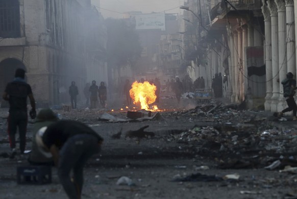 Riot police fire tear gas during clashes with anti-government demonstrators in Baghdad, Iraq, Saturday, Nov. 23, 2019. (AP Photo/Hadi Mizban)