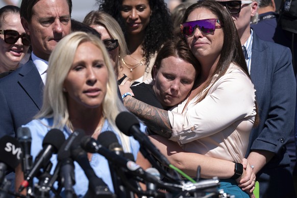 Jena-Lisa Jones, center, hugs Haley Robson, right, as Rep. Marjorie Taylor Greene, R-Ga., left, speaks during a news conference at the U.S. Capitol, Wednesday, Sept. 3, 2025, in Washington. (AP Photo/ ...