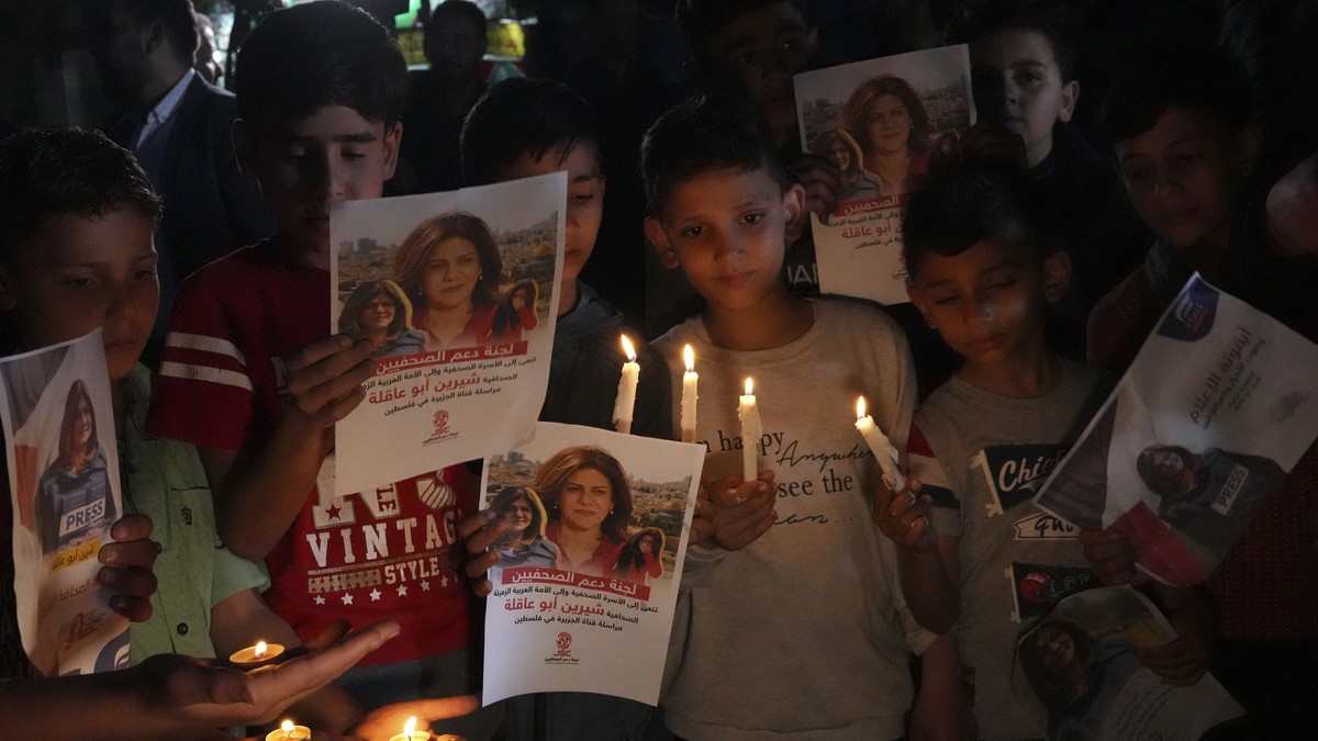 Palestinian children carry light candles and pictures of slain Al Jazeera journalist Shireen Abu Akleh, to condemn her killing, in front of the office of Al Jazeera network, in Gaza City, Wednesday, M ...