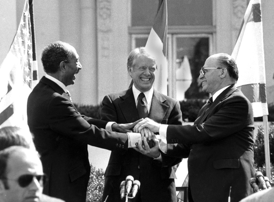 FILE - Egyptian President Anwar Sadat, left, U.S. President Jimmy Carter, center, and Israeli Prime Minister Menachem Begin clasp hands on the north lawn of the White House after signing the peace tre ...