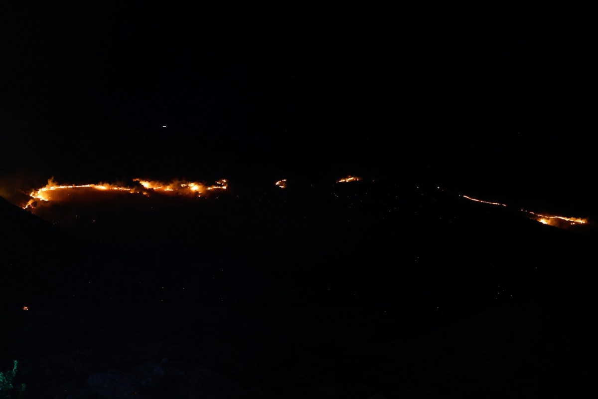 A fire is seen on Syrian side, amid the ongoing conflict in the Druze areas in Syria, seen from Majdal Shams, near the ceasefire line between the Israeli-occupied Golan Heights and Syria, July 16, 202 ...