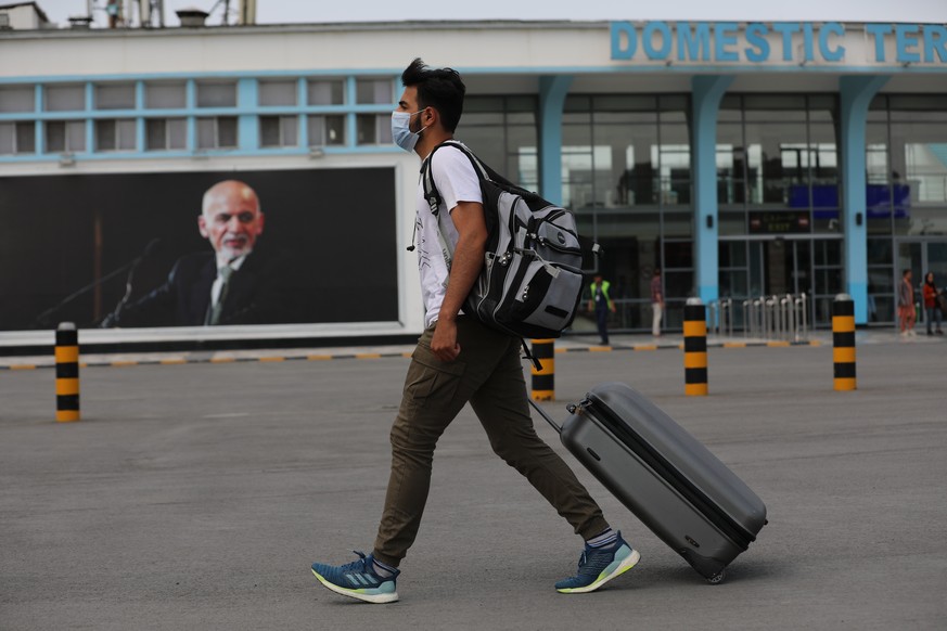 A passenger walks to the departures terminal of Hamid Karzai International Airport, in Kabul, Afghanistan, Saturday, Aug. 14, 2021. As a Taliban offensive encircles the Afghan capital, there&#039;s in ...