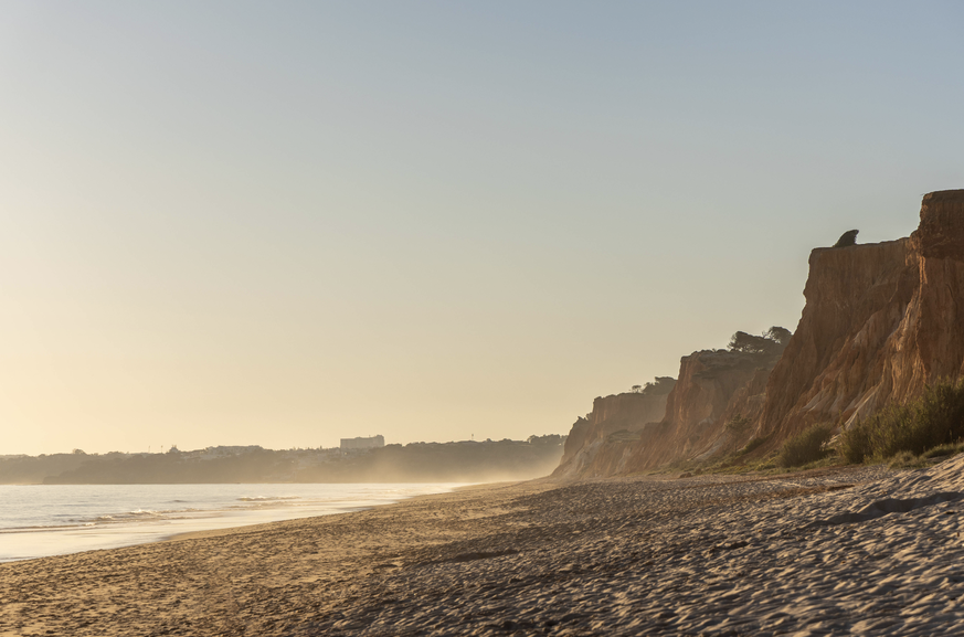Über 8 Kilometer Sand und orangefarbene Felsen – der fast schon mystische Falésia Beach in Portugal.