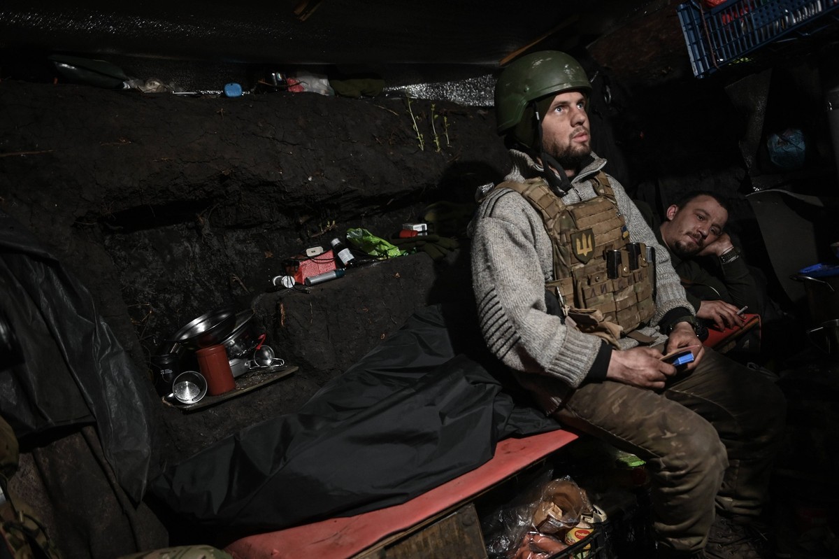 Donetsk Region, Ukraine: Ukrainian soldiers man frontline defensive positions as Russian Forces attempt to advance in the Donbas Region of Ukraine. Two Ukrainian soldiers rest on their bunk in an unde ...