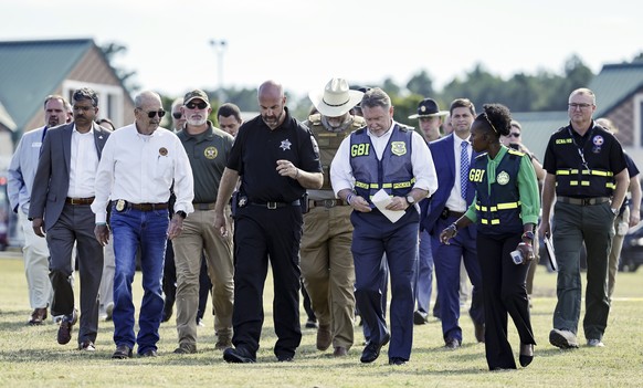 epa11585479 Law enforcement officials walk towards the media before a press conference about a shooting at Apalachee High School in Winder, Georgia, USA, 04 September 2024. According to the Georgia Bu ...