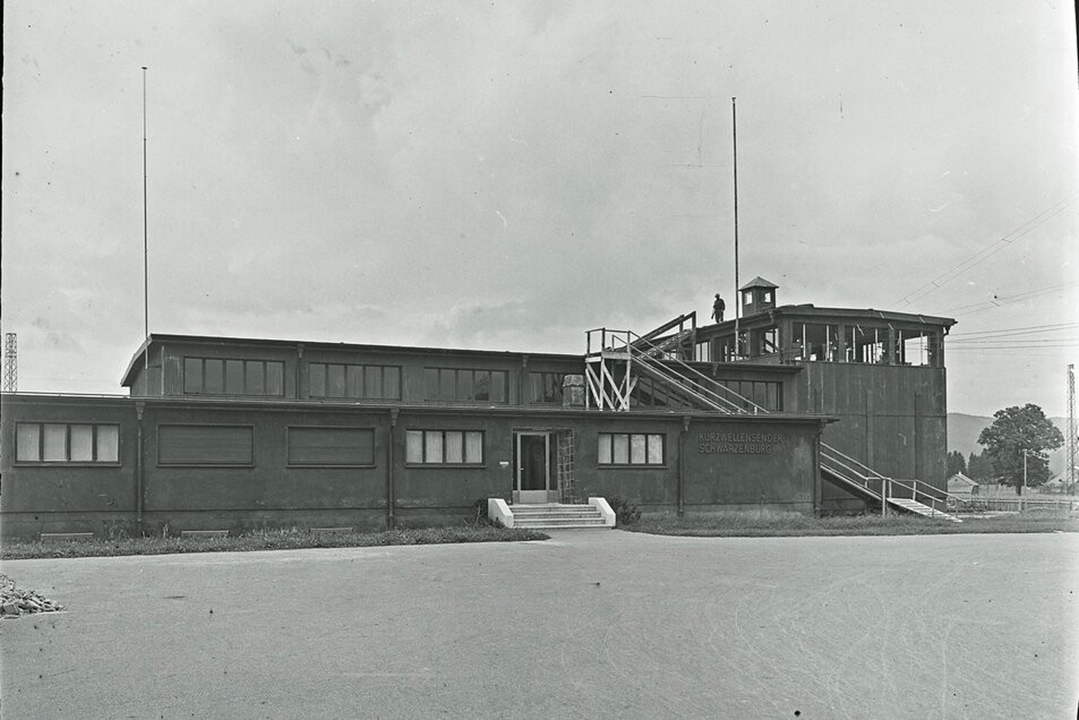 Der Kurzwellensender Schwarzenburg erhält während des Krieges einen Tarnanstrich und wird militärisch bewacht. Auf dem Dach ist auf dieser Fotografie aus den Kriegsjahren ein Soldat zu sehen.