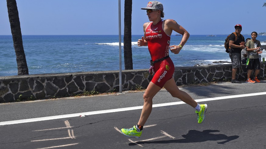 Spectators cheer on Daniela Ryf, of Switzerland, during the marathon portion of the Ironman World Championship Triathlon, Saturday, Oct. 10, 2015, in Kailua-Kona, Hawaii. (AP Photo/Mark J. Terrill)