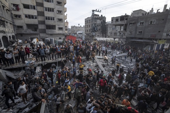Palestinians search for bodies and survivors in the rubble of a residential building destroyed in an Israeli airstrike, in Rafah southern Gaza Strip, Wednesday, Dec. 20, 2023. (AP Photo/Fatima Shbair)