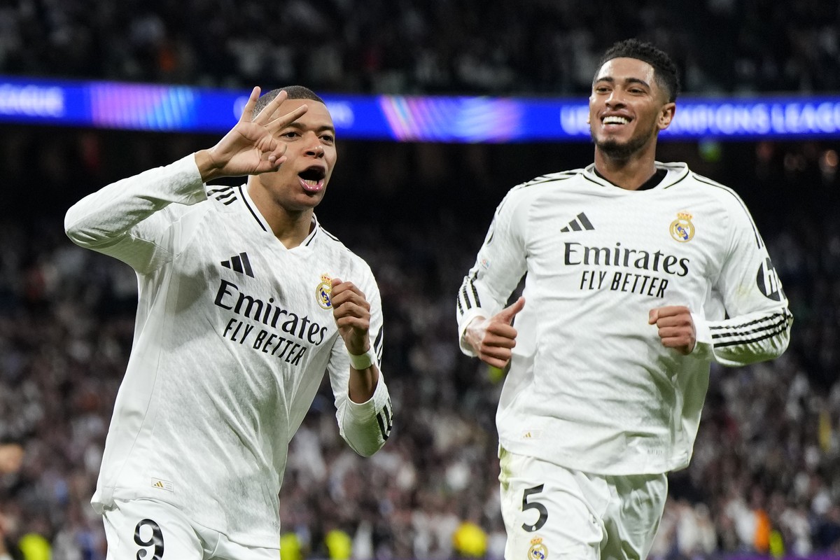 Real Madrid's Kylian Mbappe celebrates with Real Madrid's Jude Bellingham, right, after scoring his sides third goal during the Champions League playoff second leg soccer match between Real  ...