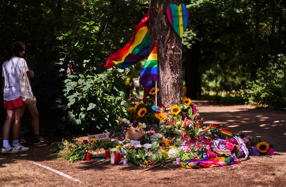 Flowers and rainbow flags placed at a tree in the Tiergarten Park near the scene where a car rammed into people after Saturday's Pride March in Berlin, Germany, Monday, July 27, 2026. (AP Photo/M ...