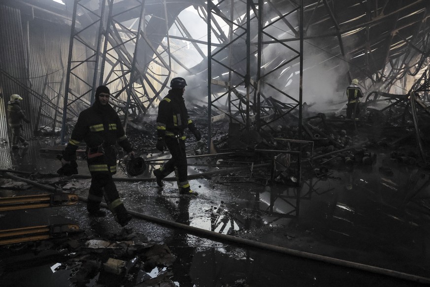 epa11047960 Ukrainian rescuers work at the site of a rocket attack on a civilian warehouse in Kyiv (Kiev), Ukraine, 29 December 2023, amid the Russian invasion. At least 16 people have died and dozens ...