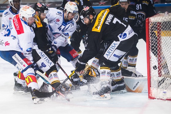 Zurich&#039;s player Mike Kuenzle, left, scores the 0-1 goal against Lugano&#039;s Philippe Furrer, right, and Lugano&#039;s Elvis Merzlikins, bottom, during the first match of the playoff final of th ...