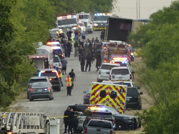 In San Antonio starben im Anhänger eines LKWs (hinten rechts) duzende Migranten. Polizeiautos und Sicherheitskräfte vor Ort, 27. Juni 2022.