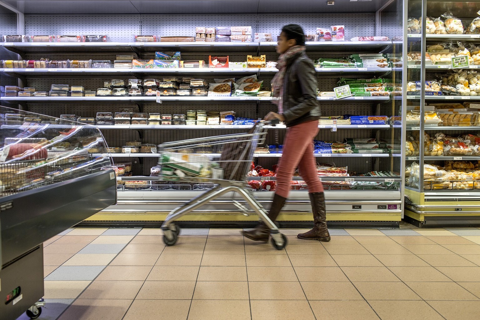 A customer pushes a supermarket trolley past the refrigerated shelf, pictured on March 5, 2013, at the Migros branch in Baden, Switzerland. Migros is Switzerland&#039;s the largest retail company. (KE ...