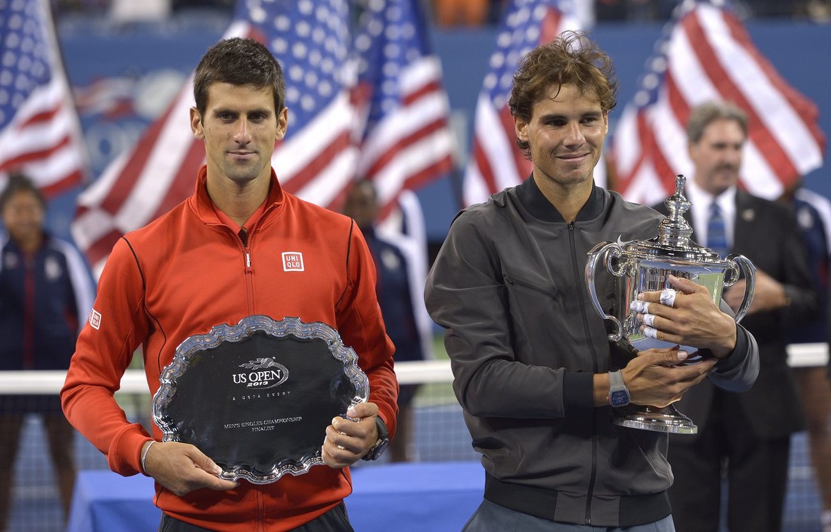 epa03860249 Rafael Nadal of Spain (R) poses with the championship trophy after defeating Novak Djokovic of Serbia (L) who holds the runner up trophy after the men's final on the fifteenth day of  ...