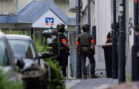 epa12941412 Armed police officers secure the area outside a Volksbank branch in Sinzig, Germany, 08 May 2026. According to police, several perpetrators have taken hostages at the bank branch in the Rh ...