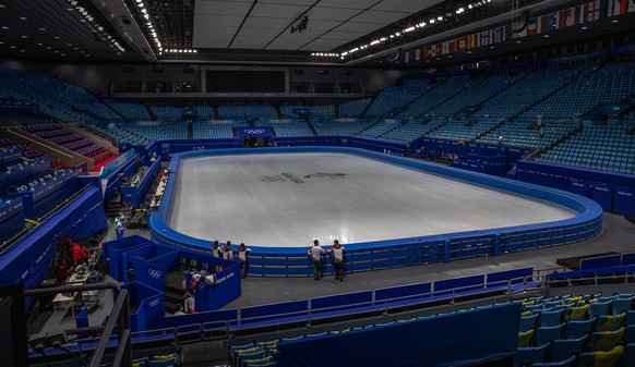 epa09711658 Olympic staff stand at the Capital Indoor Stadium, which will be used during the 2022 Winter Olympics for figure skating and short track speed skating, in Beijing, China, 27 January 2022.  ...