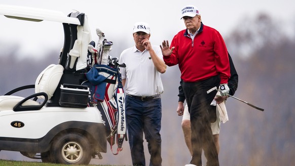 epaselect epa08834479 US President Donald J. Trump (R) plays golf for the 143rd time since becoming president at the Trump National Golf Club in Sterling, Virginia, USA, 21 November 2020. The presiden ...