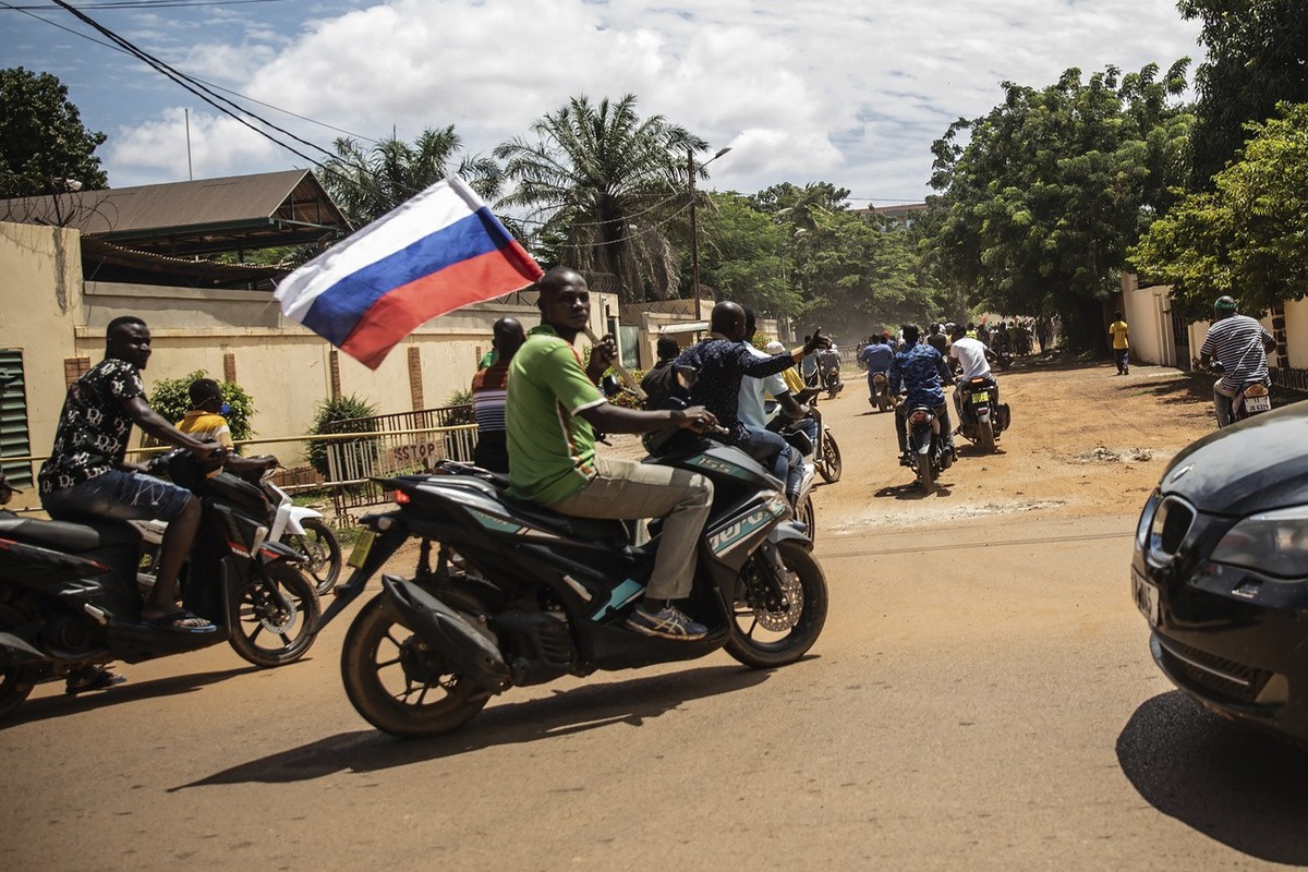 FILE - Supporters of Capt. Ibrahim Traore parade waving a Russian flag in the streets of Ouagadougou, Burkina Faso, Sunday, Oct. 2, 2022. A coup attempt against Burkina Faso's military government ...