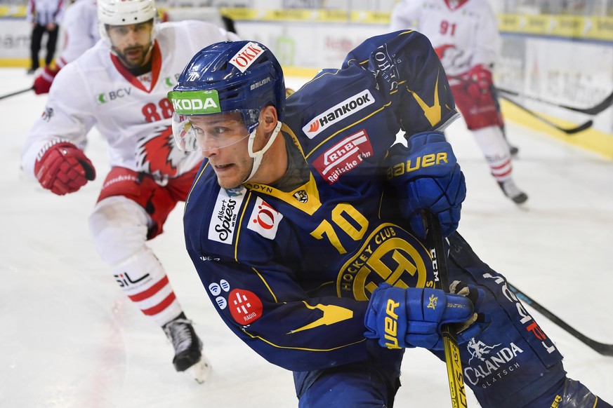 Davos&#039; Enzo Corvi, Mitte, verfolgt von Lausannes Matteo Nodari, links, beim Eishockey-Qualifikationsspiel der National League A zwischen dem HC Davos und den HC Lausanne, am Samstag, 7. Dezember  ...