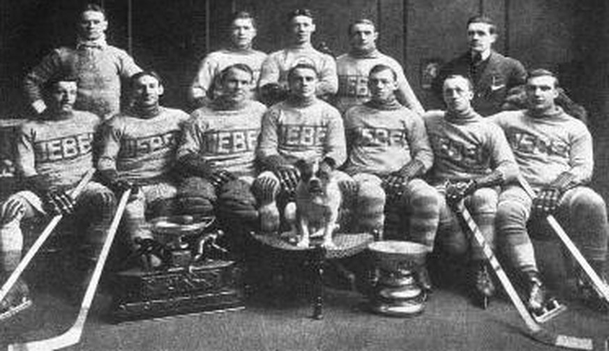 Malone (vorne in der Mitte, hinter der Bulldogge) 1913 mit Teamkollegen, Maskottchen und Stanley Cup.