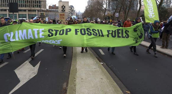 epa11009010 People carry a banner reading &#039;climate stop fossil fuels&#039; during the annual Big Climate March 2023, in Brussels, Belgium, 03 December 2023. The protest, coinciding with the 2023  ...