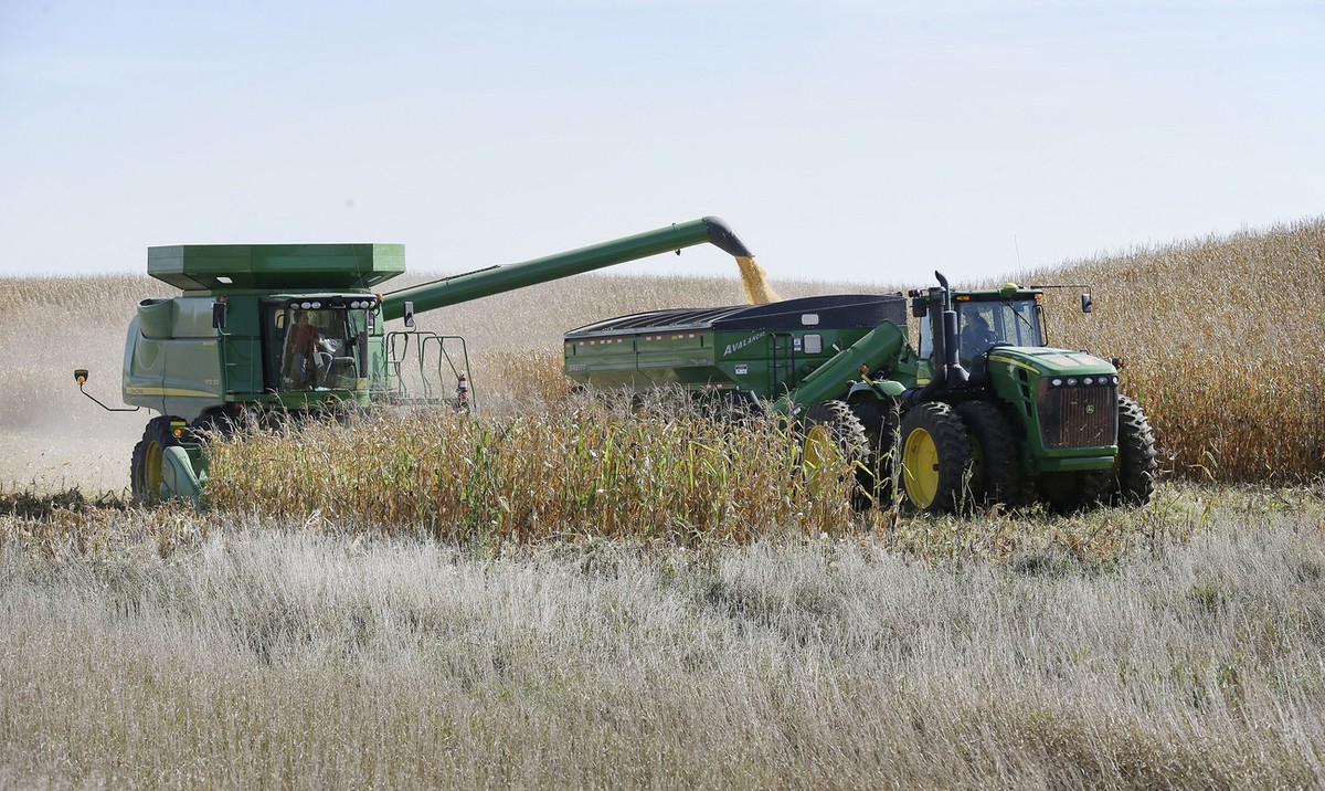 A farmer dumps corn in a grain trailer as he harvests a field, Monday, Oct. 7, 2013, near Clear Lake, Iowa. Farmers and livestock producers use the reports put out by the National Agriculture Statisti ...
