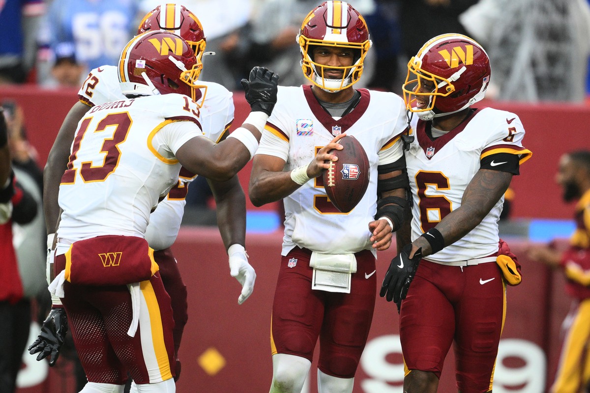 Washington Commanders quarterback Jayden Daniels (5) celebrates with teammates after rushing for a touchdown during the second half of an NFL football game against the New York Giants in Landover, Md. ...