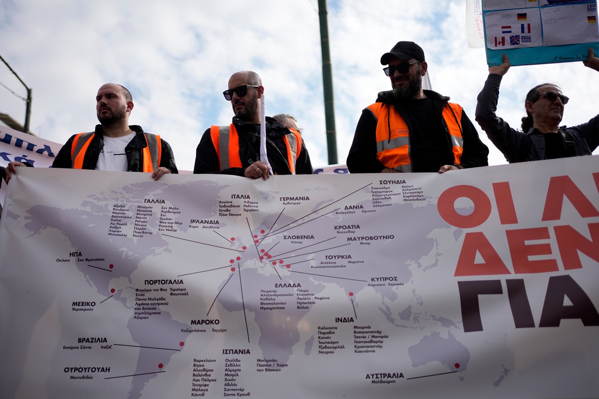 Dockworkers hold a banner during a 24-hour seafarers' strike over pay, working conditions and safety, alongside protests against the transport of military equipment through ports at the port of P ...