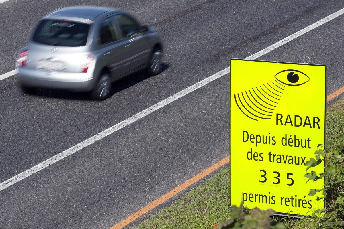 Un vehicule passe devant un panneau de la Police cantonale Vaudoise signalant que 335 permis de conduire ont ete retire pour exces de vitesse dans la zone de travaux sur l'autoroute A1 entre Laus ...