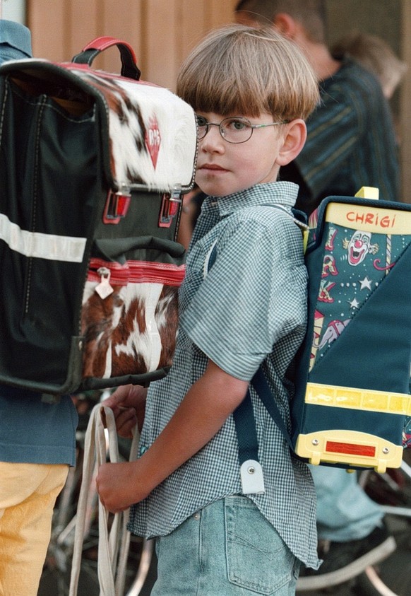 Der 6jaehrige Chrigi wartet am Montagmorgen, 10. August 1998, vor dem Schulhaus in Schuepbach (BE) im Emmental auf das erste Laeuten der Schulglocke seiner Schullaufbahn. (KEYSTONE/Alessandro della Va ...