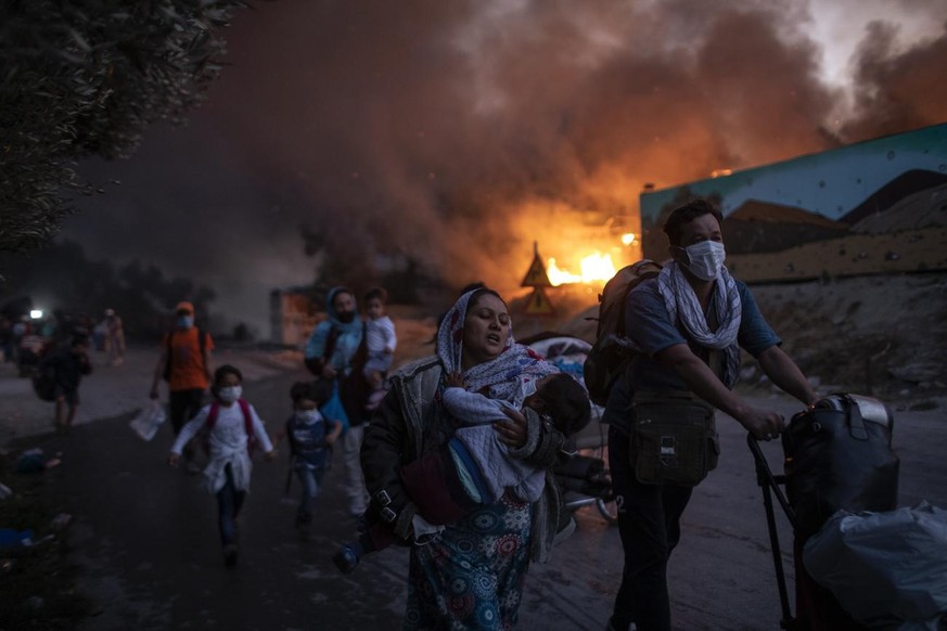 Migrants flee from the Moria refugee camp during a second fire, on the northeastern Aegean island of Lesbos, Greece, on Wednesday, Sept. 9, 2020. Fire struck again Wednesday night in Greece's not ...