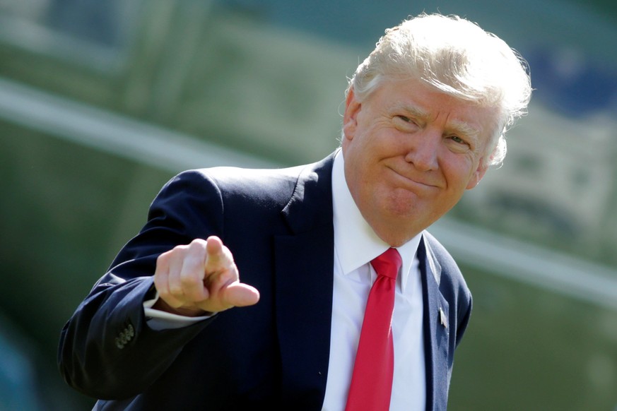 U.S. President Donald Trump points to the media up as he walks on the South Lawn upon his return to the White House in Washington, U.S., February 24, 2017. REUTERS/Yuri Gripas