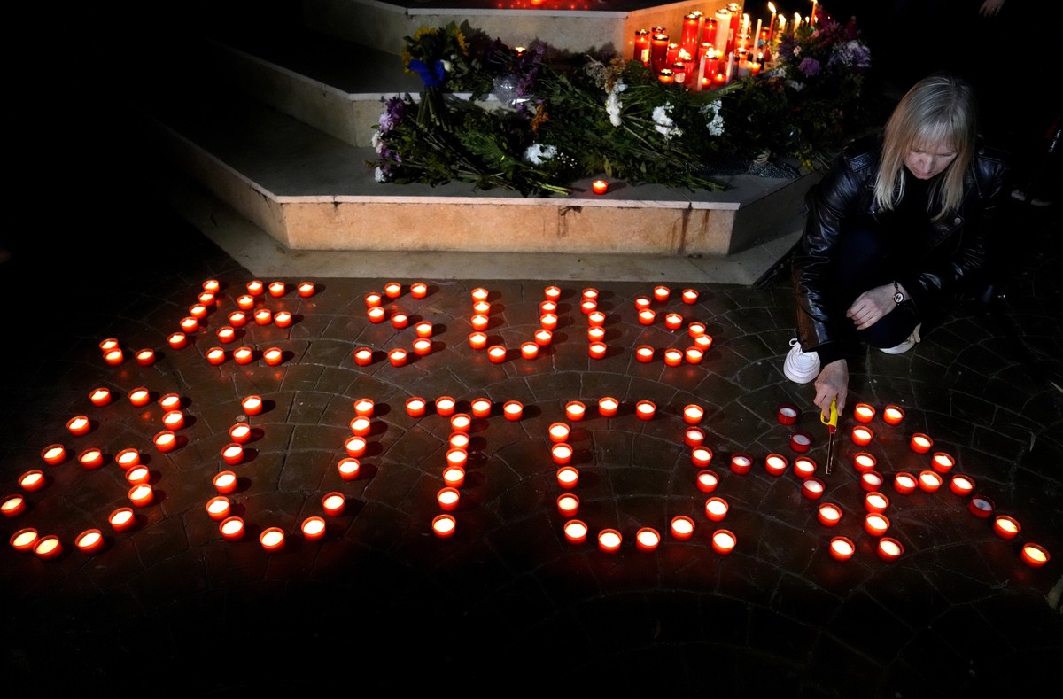 An Ukrainian woman who lives in Lebanon, lights candle with words: "I am Butcha" to commemorate the civilians who were killed during the Russian occupation in Bucha, outside the Ukrainian em ...