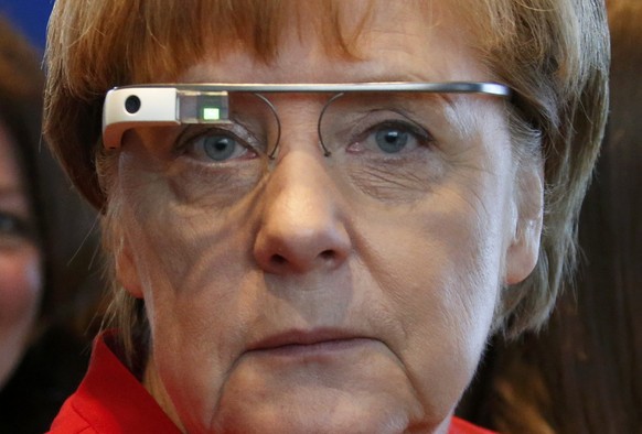 German Chancellor Angela Merkel wears Google Glass eyewear as she visits a booth of Nokia where students developed an interactive communication software to repair mobile communications equipment abroa ...