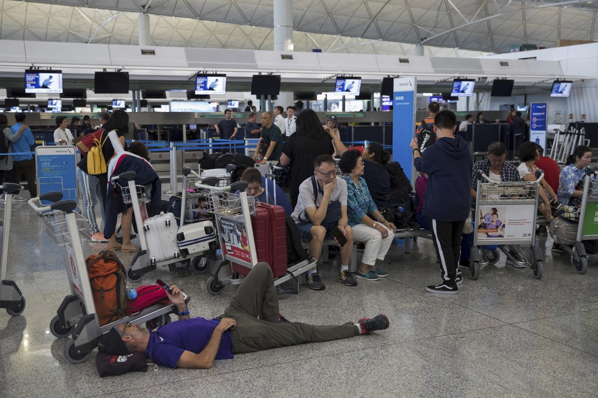 Stranded travelers wait in the departure hall of the Hong Kong International Airport in Hong Kong, Tuesday, Aug. 13, 2019. Protesters severely crippled operations at Hong Kong's international air ...