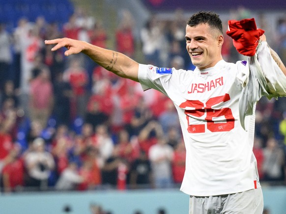 Switzerland&#039;s midfielder Granit Xhaka celebrates the victory and the qualification with the shirt of Switzerland&#039;s midfielder Ardon Jashari after the FIFA World Cup Qatar 2022 group G soccer ...