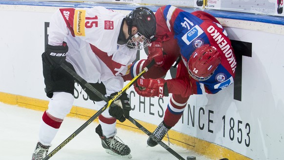 Switzerland&#039;s Nico Hischier, left, and Russia&#039;s Alexander Yakovenko, right, vie for the puck during a ice hockey U18 World Championships quarter final match between Switzerland and Russia, a ...