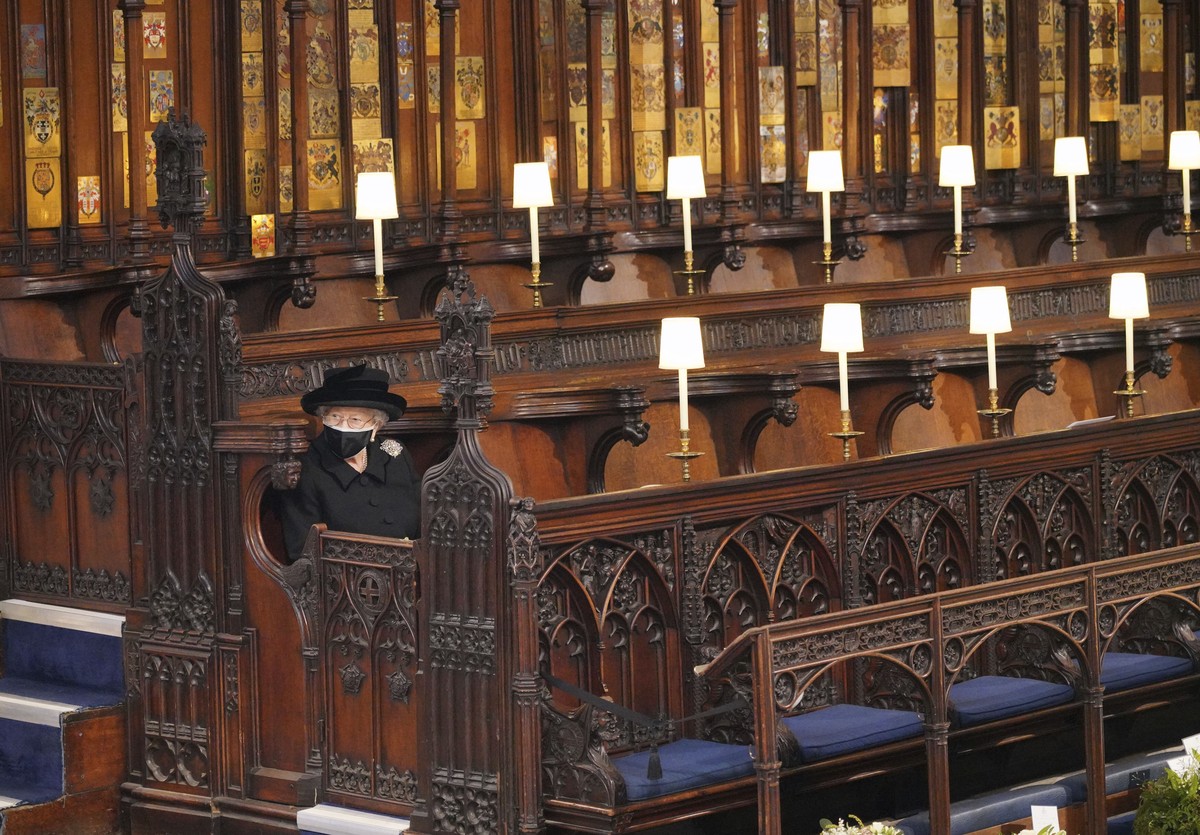 Britain's Queen Elizabeth II takes her seat during the funeral of Prince Philip, the man who had been by the Queen's side for 73 years, at Windsor Castle, Windsor, England, Saturday April 17 ...