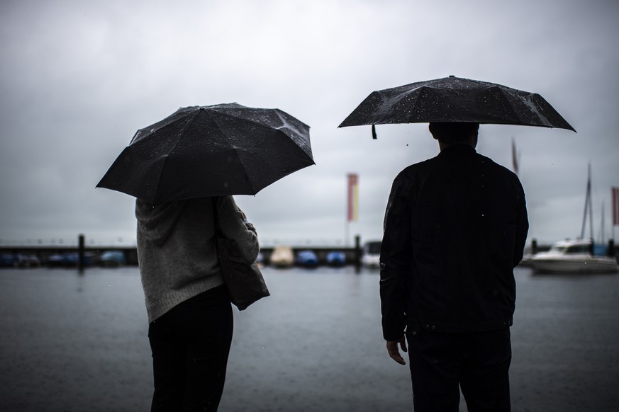 Menschen mit Regenschirmen, aufgenommen am Donnerstag, 8. Juli 2021, in Rorschach. (KEYSTONE/Gian Ehrenzeller)