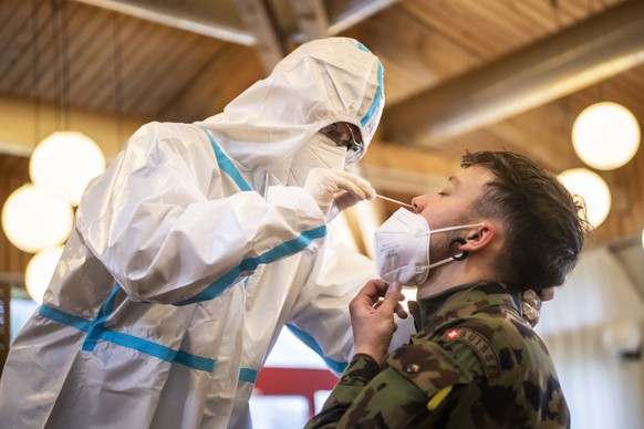 Un militaire de l'Armee suisse du bataillon d'hopital 2, portant un masque FFP2, recoit un test antigenique avant de commencer l'entree en service afin de soutenir les cantons dans la lutte contre le  ...